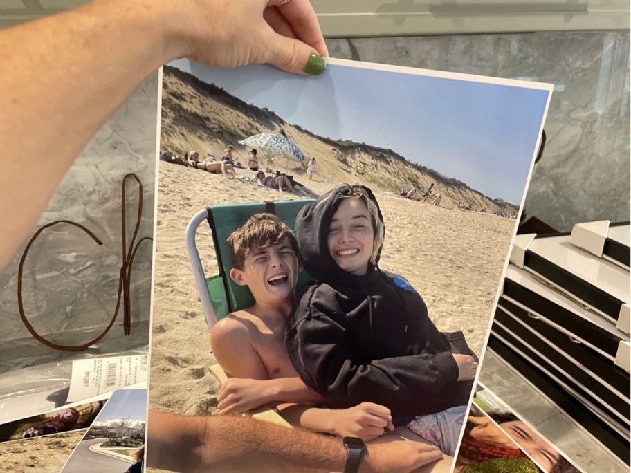 hand holding photo of two kids on beach chair
