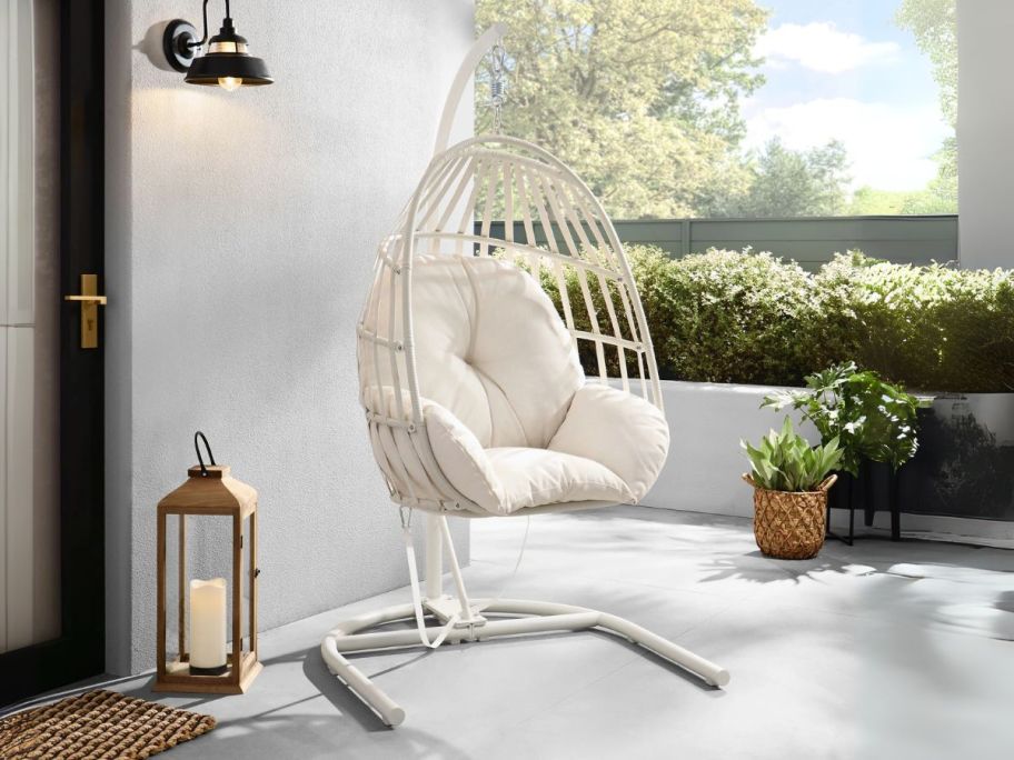 white Mainstays Wicker Outdoor Patio Hanging Egg Chair on porch