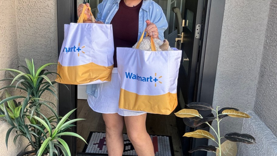 woman holding two walmart plus delivery bags on her doorstep
