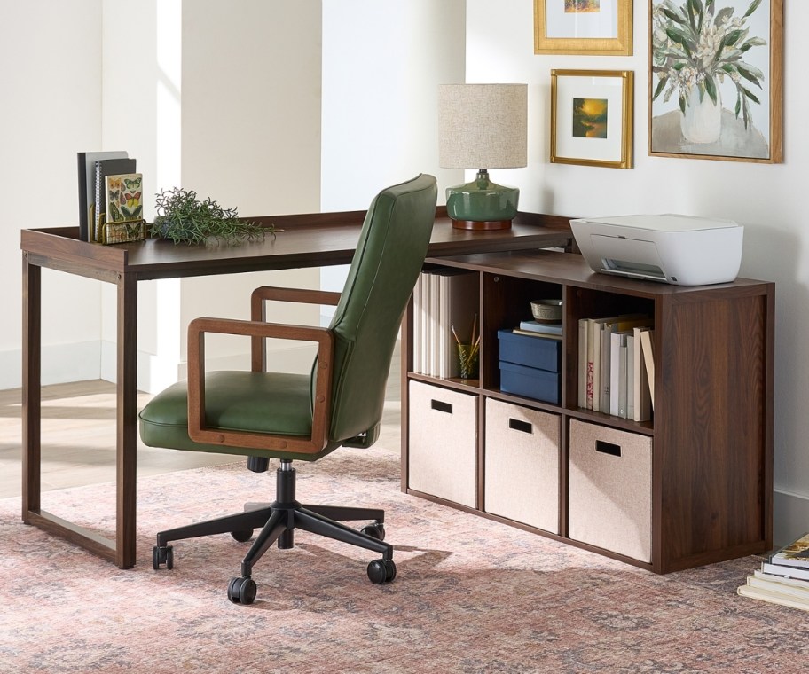 an l-shaped desk and green desk chair