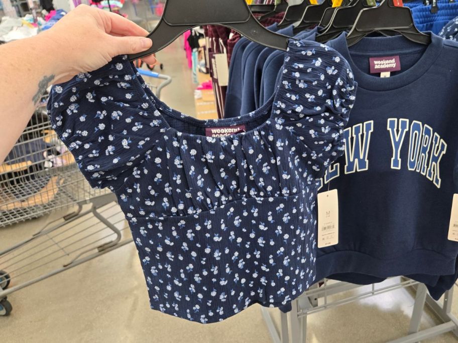 hand holding blue and white Weekend Academy Girls Cap Sleeve Top in store