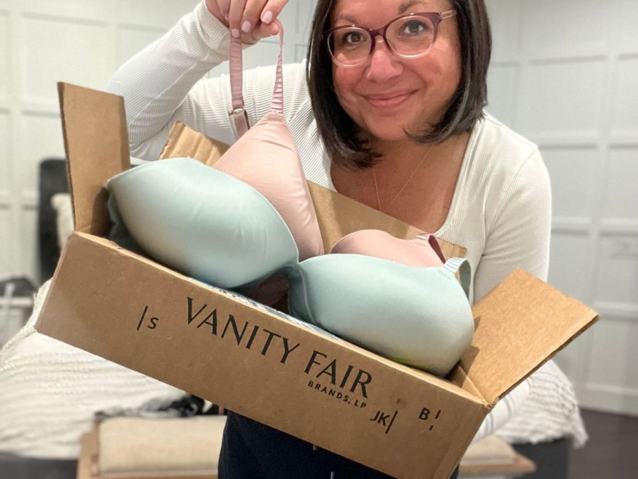 woman holding vanity bras on the outside of their box
